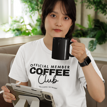 Woman drinking coffee wearing a white Official Member Coffee Club "No Coffee. No Work" t-shirt.