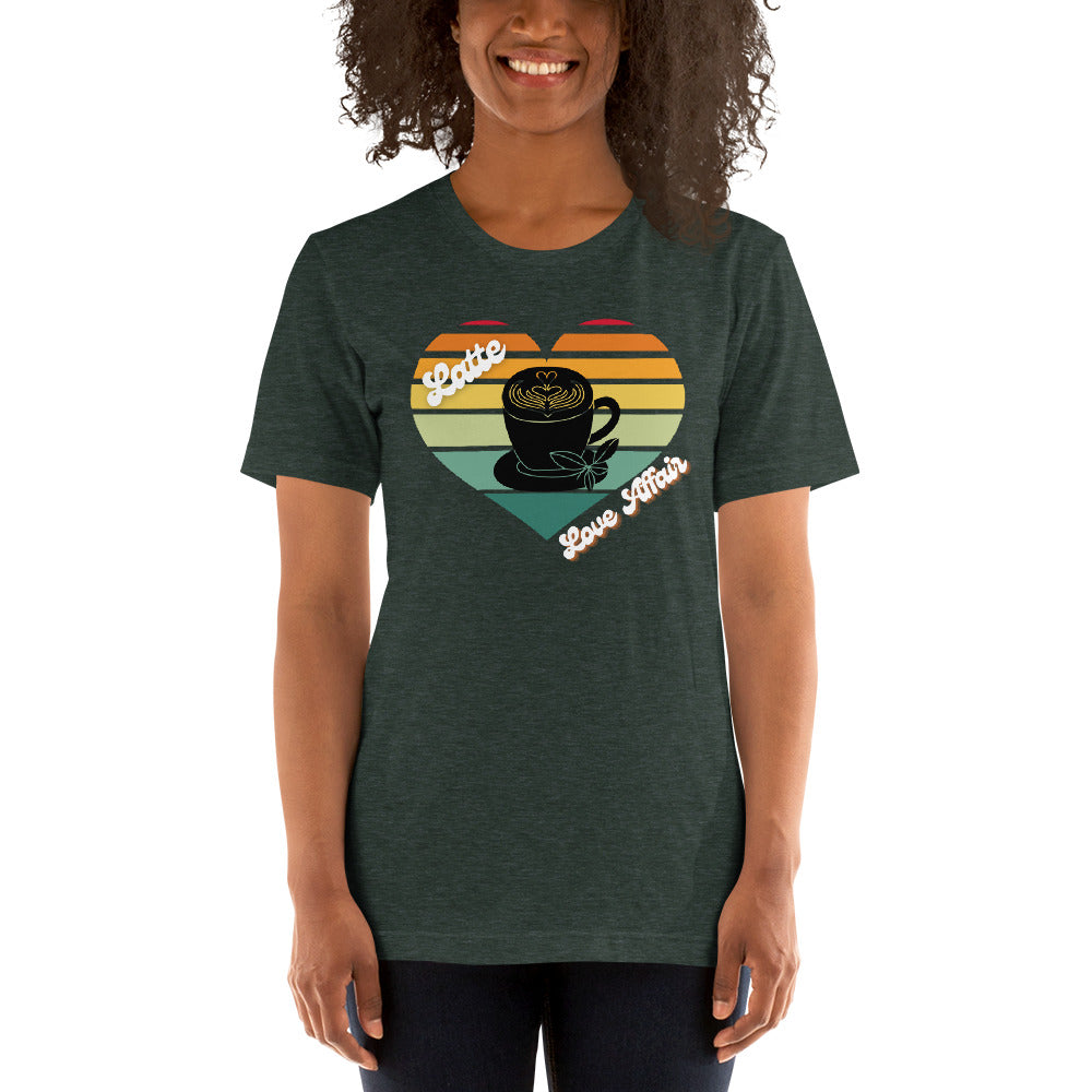 Smiling woman wearing a heather forest green coffee t-shirt that has a retro heart sunset and the words Latte Love Affair 