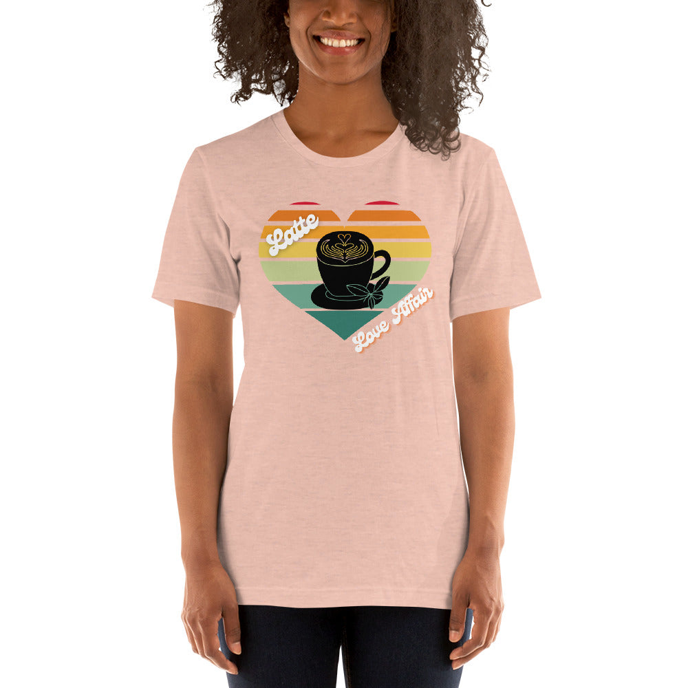 Smiling woman wearing a heather prism peach coffee t-shirt that has a retro heart sunset and the words Latte Love Affair 