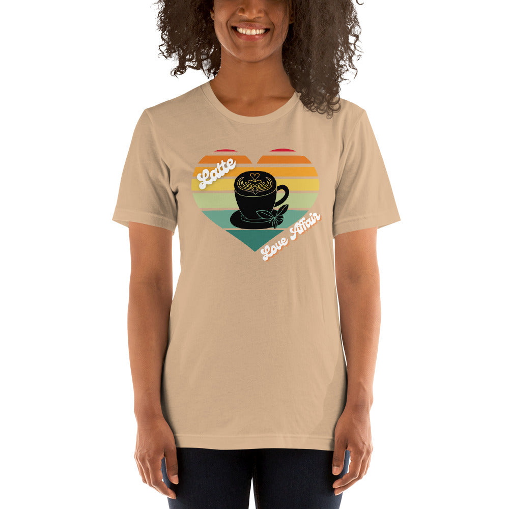 Smiling woman wearing a tan coffee t-shirt that has a retro heart sunset and the words Latte Love Affair 