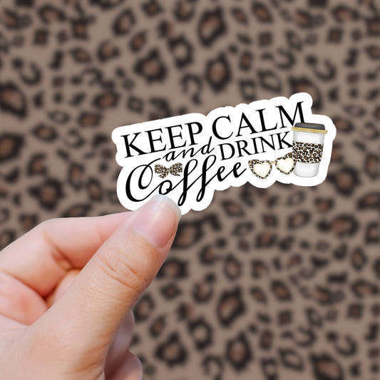 Hand holding a Keep Calm and Drink Coffee sticker with leopard print in the background